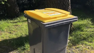 Bac de tri à couvercle jaune sorti pour la collecte